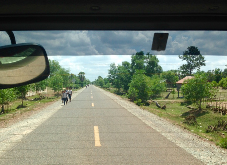 Cambodian school kids walking on the side of the road in 100 degree heat
