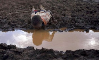 child drinking dirty water